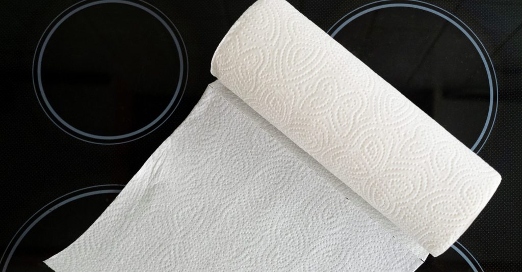 a roll of paper kitchen towels unfurling on a stovetop.